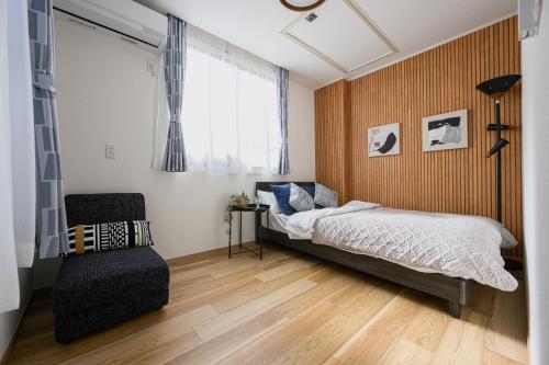 a bedroom with a bed and a chair at Direct Haneda Access &Onsen 1-min Walk SAMURAI STAY ZEN in Tokyo