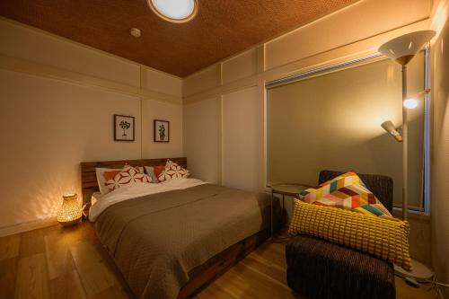 a bedroom with a bed and a chair in it at Direct Haneda Access &Onsen 1-min Walk SAMURAI STAY ZEN in Tokyo