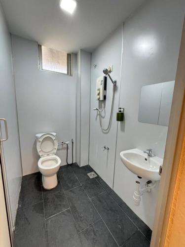 a bathroom with a toilet and a sink at Skudai Sojourn in Skudai
