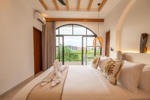 a bedroom with a large bed with a large window at Sapta Cemagi - Villa Deluna in Cemagi