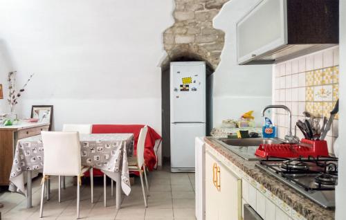 a kitchen with a table and a white refrigerator at Casa Herea in Ragusa