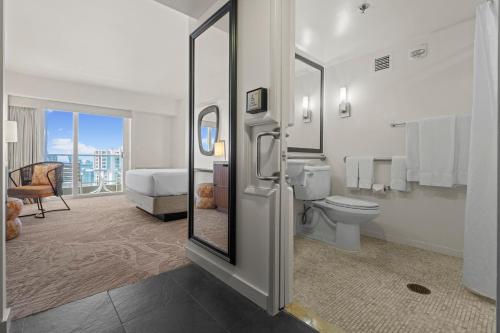 a bathroom with a toilet and a bedroom with a balcony at Ala Moana Honolulu by Mantra in Honolulu