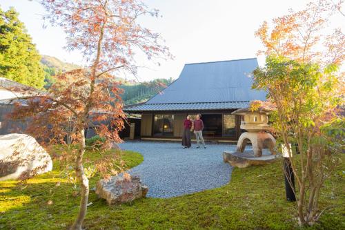 two people standing in front of a building at NIPPONIA 美山鶴ヶ岡 Mountain Village in Ōno