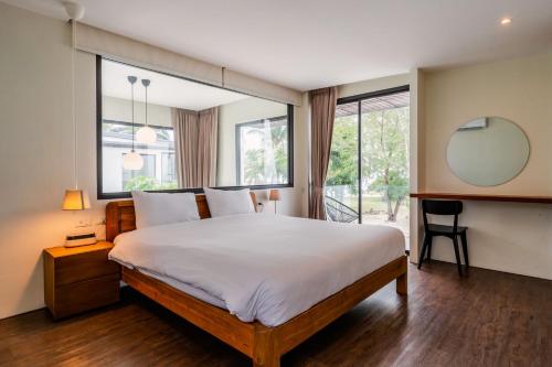 a bedroom with a large bed and a mirror at Meet Up Villa in Ban Nai Khao