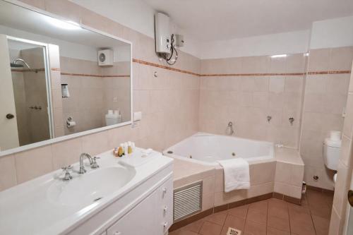 a bathroom with a tub and a sink and a toilet at West Beach Lagoon 206 Ground Floor 2mins beach in Perth