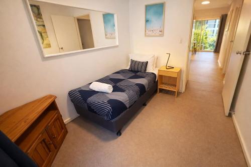a bedroom with a bed and a dresser and a mirror at West Beach Lagoon 206 Ground Floor 2mins beach in Perth