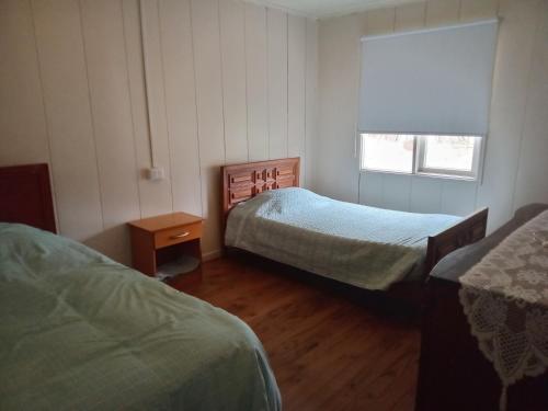 a small bedroom with two beds and a window at Don José in Los Molles