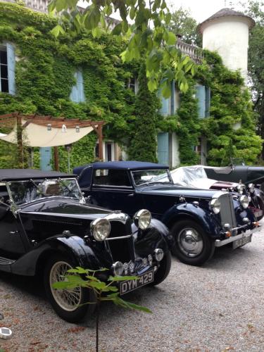 two old cars parked in front of a building at Domaine de la Vivarié in Castres