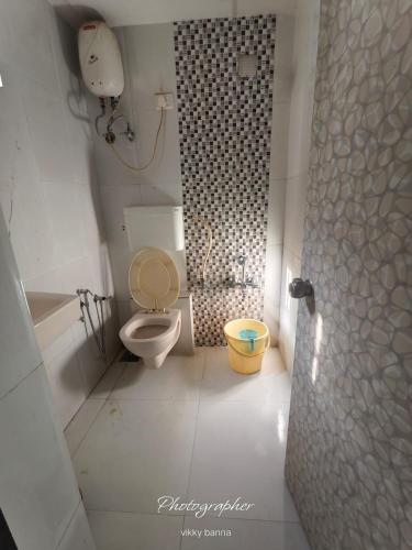 a small bathroom with a toilet and a shower at Hotel New Vinayak in Ahmedabad