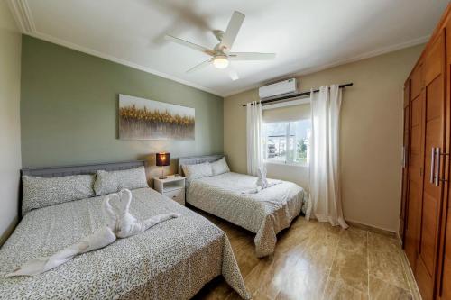 a bedroom with two beds and a ceiling fan at Corte Sea A302, Luxury Penthouse in Punta Cana
