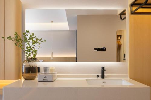 a bathroom with a sink and a large mirror at Surprise Hotel Chengdu in Chengdu