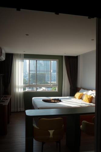 a hotel room with a bed and a window at Shine Aparthotels Sukhumvit Thonglor in Bangkok