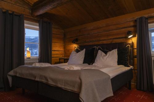 a bedroom with two beds in a log cabin at Hemavans Wärdshus in Hemavan