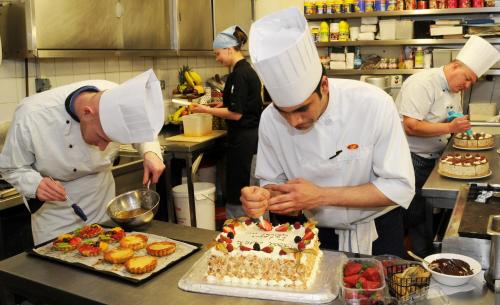 two chefs cutting into a cake in a kitchen at Park House Hotel in Galway