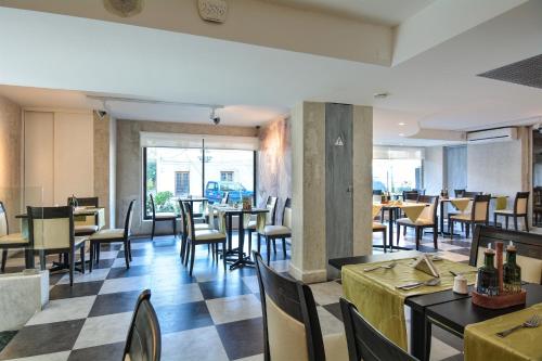 a dining room with tables and chairs and a cafeteria at Hotel Eurotel Providencia in Santiago