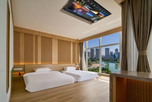 a hotel room with two beds and a flat screen tv at 苏州奇遇派东方庭院Qiyupai Eastern Courtyard Hotel in Suzhou