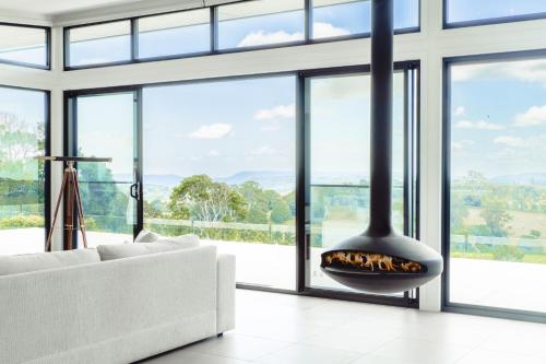 a living room with a fireplace in front of windows at Beechmont Estate in Beechmont