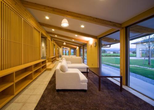 a living room with two white couches and a table at ウェルネスハウスさらい in Nomi