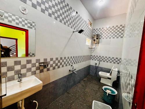 a bathroom with a sink and a toilet and a mirror at Hampi Icon Palace in New Hampi