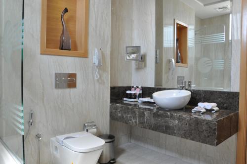 a bathroom with a sink and a toilet at Fortune Park Hotel in Dubai