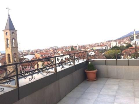 a balcony with a view of a city with a church at Hotel Antika in Prizren