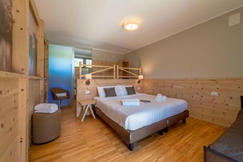 a bedroom with a large bed in a room with wooden walls at Agritur La Dolce Mela - Adults Only in Vezzano