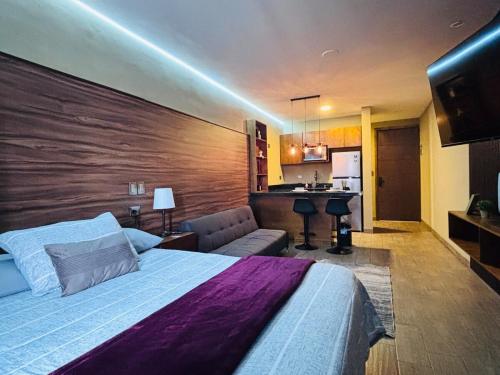 a large bedroom with a large bed and a couch at Loft moderno y acogedor in Durango