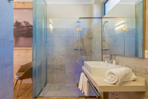 a bathroom with a glass shower and a sink at Agritur La Dolce Mela - Adults Only in Vezzano