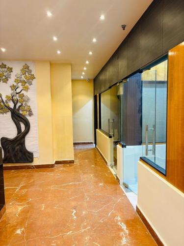 a lobby with a painting of a tree on the wall at Hotel Imperial Plaza Asansol in Āsansol