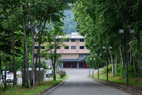 an empty street with trees and a building at Hotel Kanronomori in Niseko