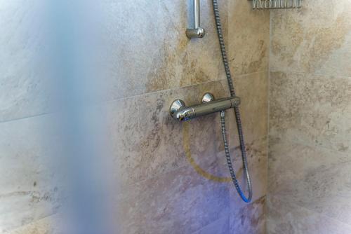 a shower with a shower head in a bathroom at Agritur La Dolce Mela - Adults Only in Vezzano