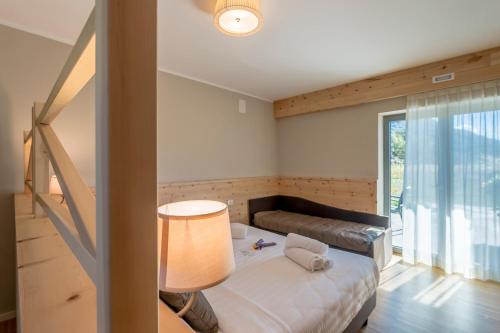 a small bedroom with a bed and a lamp at Agritur La Dolce Mela - Adults Only in Vezzano