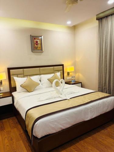 a bedroom with a large bed with white sheets and pillows at Hotel Imperial Plaza Asansol in Āsansol