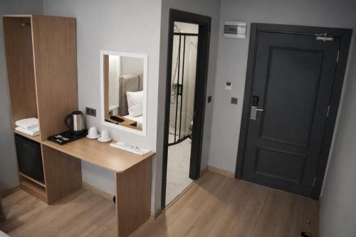 a room with a desk and a mirror and a door at Olen Uskudar Hotel in Istanbul