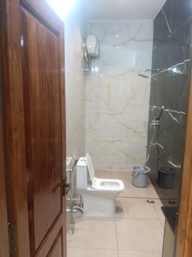 a bathroom with a toilet and a shower at VGN Convention Centre in Vāniyambādi