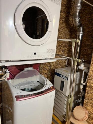 a washing machine in a bathroom with a washer at Hokkaido Bed & Bagel in Eniwa