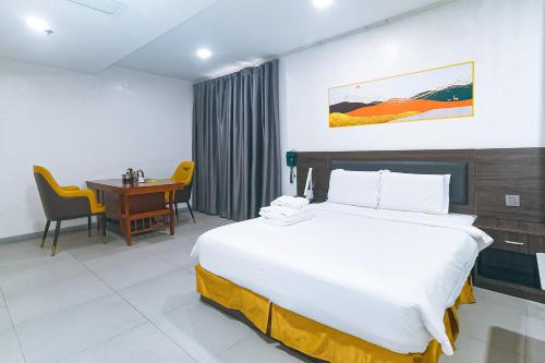 a hotel room with a bed and a desk at Luna Hotel Pasay in Manila