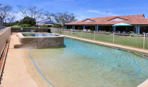 a swimming pool in a yard with a fence at Villa 25 Coral Cove Resort in Bargara