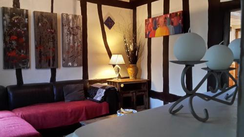 un salon avec un canapé et des tableaux au mur dans l'établissement Les Hirondelles, à Lyons-la-Forêt