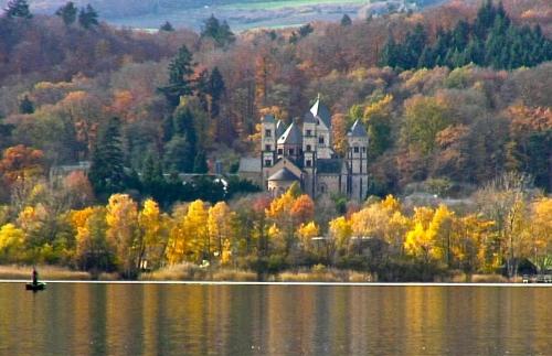 a castle sitting on top of a hill next to a lake at City Apartment Mendig in Mendig
