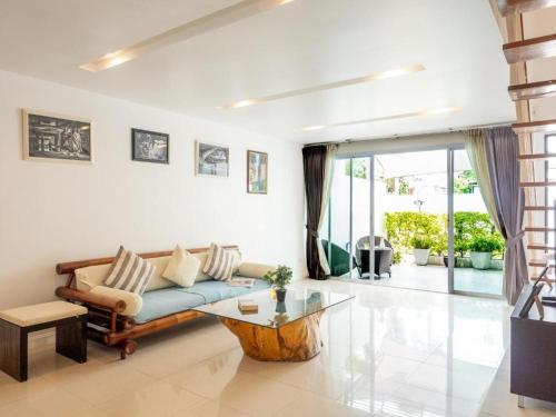 a living room with a blue couch and a table at Townhouse Six9 The Pool Residence in Koh Samui