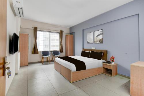 a bedroom with a bed and a television in it at Super Collection O Katraj Bus Stop Formerly Indu Ville in Māngvādi