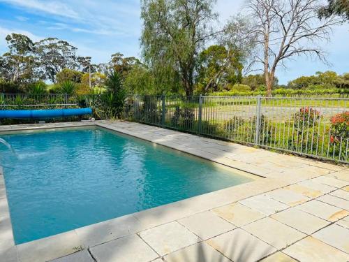 a swimming pool in a yard with a fence at The Gabby's Holiday House in Nuriootpa