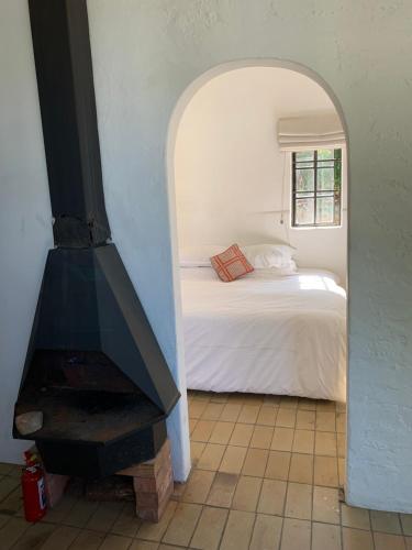 a bedroom with a bed and an arched doorway at The Barn, at Glenora Avenue in Somerset West