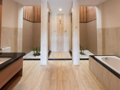 a bathroom with a bath tub and a sink at Airindah Villa in Gili Islands