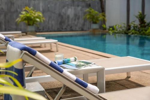 a pool with a chair and a drink on a table at Townhouse Six9 The Pool Residence in Koh Samui