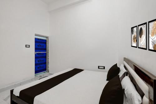a white bedroom with a bed and a window at SPOT ON Galaxy Hotal in Prayagraj