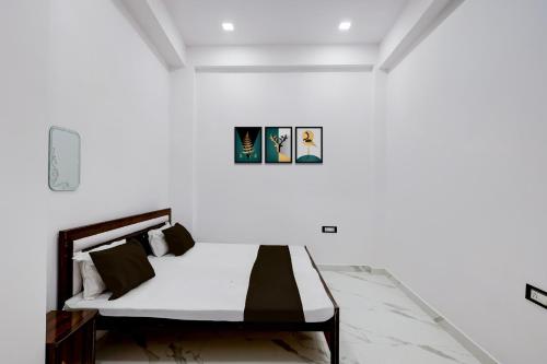 a bedroom with a bed in a white wall at SPOT ON Galaxy Hotal in Prayagraj