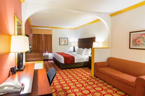 a hotel room with a bed and a desk at Quality Suites Lubbock Southwest in Lubbock