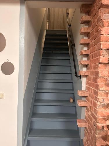 a staircase in a house with a brick wall at Chambre de charme dans maison coloniale in Noumea